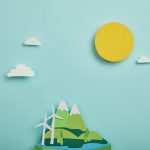 top view of paper cut planet with renewable energy sources on turquoise background, earth day
