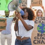 Young multiracial people demonstrate on the street with banner for the climate change